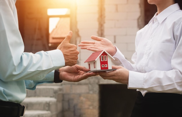 Businessmen shake hands and agree to buy and sell houses