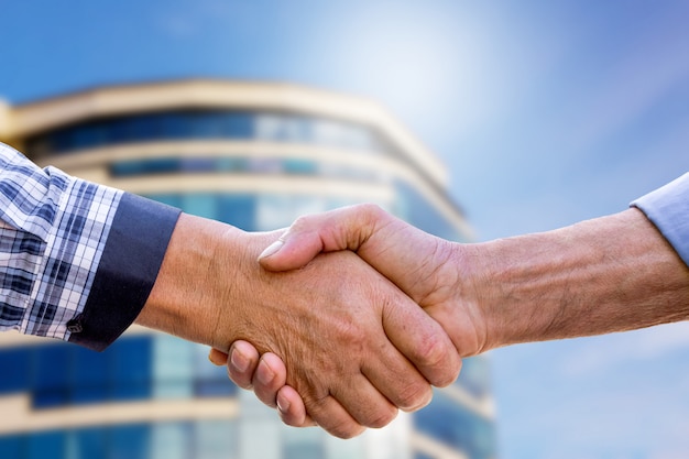 Businessmen shaking hands when buying a home. Handshake of men on modern home