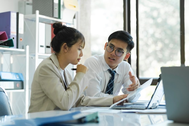 Businesspeople are working by discuss and analyses their project by using laptop and graphs