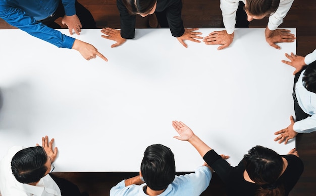 Businesspeople on meeting table pointing to empty space Prudent