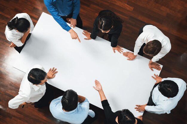 Businesspeople on meeting table pointing to empty space Prudent