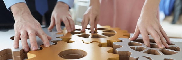 Businesspeople put wooden gears on workplace together work in team