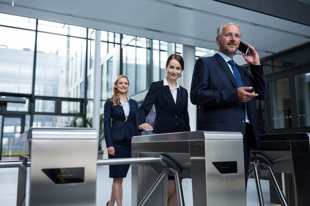 Businesspeople scanning their cards at turnstile gate