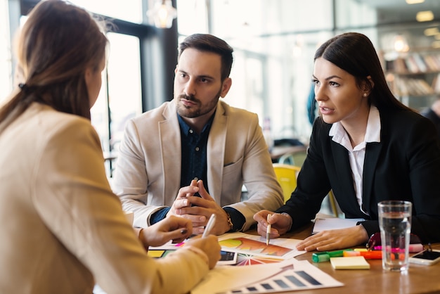 Businesspeople in tense business meeting analyzing financial histograms.