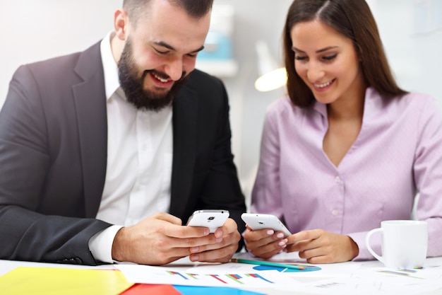 Businesspeople using their smartphones in office