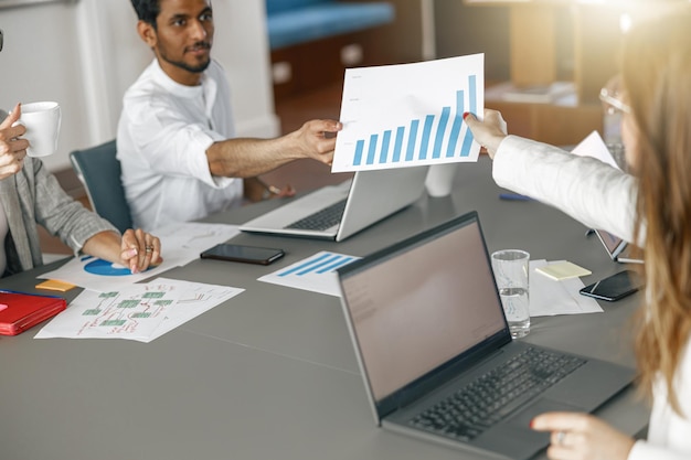 Businesspeople working together in bright office sitting at desk