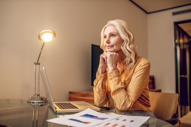 Businesswoman. Blonde stylish businesswoman working at the table and looking involved