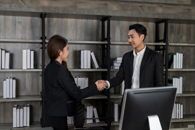 Businesswoman and businessman shaking hands with positive mood in work office successful contract business negotiation meeting