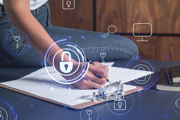 A businesswoman in casual wear signing the contract to prevent probability of risks in cyber security Padlock Hologram icons over the working desk