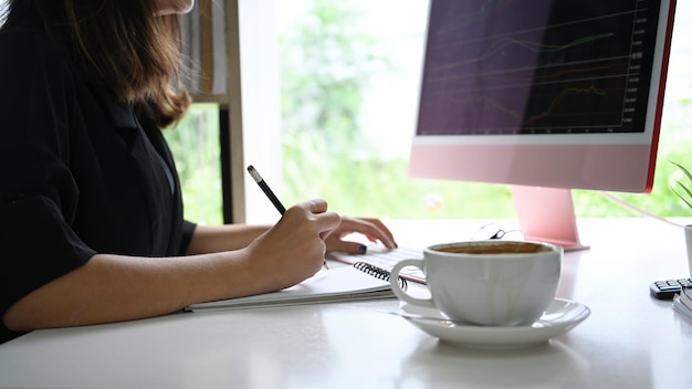 Businesswoman checking stock market on desktop computer