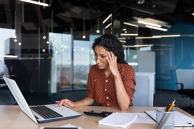 Businesswoman disappointed and sad at work not happy with the result of achievement at work hispanic