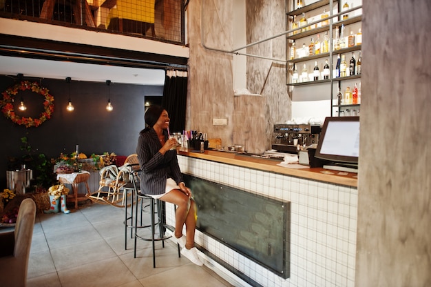 Businesswoman drinking cocktail lemonade in cafe at the bar