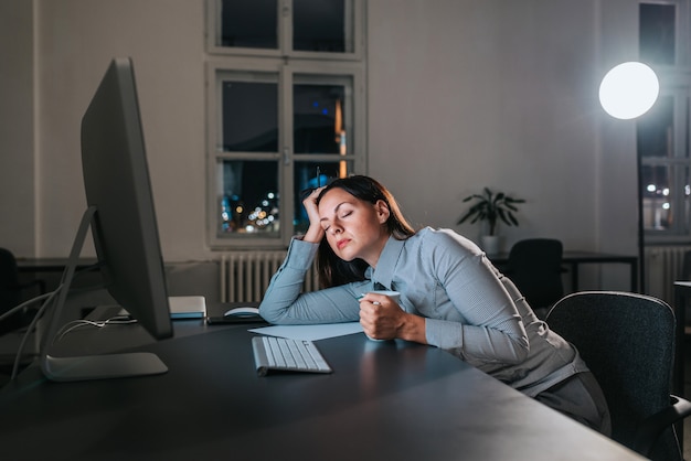 Businesswoman fell asleep at office desk. Working overtime.