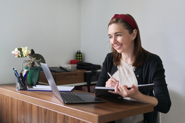 Businesswoman female teacher working online at home with laptop using video call