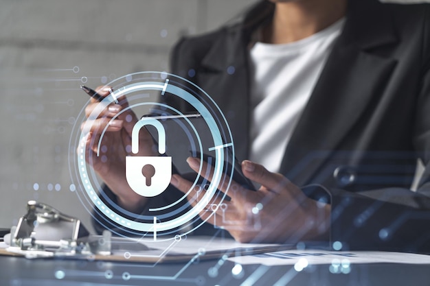 Businesswoman in formal wear signing the contract to prevent probability of risks in cyber security Checking the phone Padlock Hologram icons over the working desk