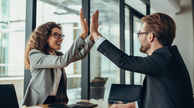 Businesswoman giving a high five to male colleague in meeting Business professionals high five during a meeting in boardroom