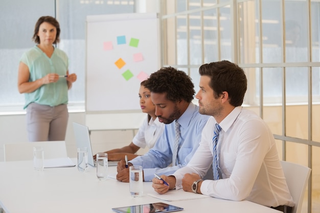 Businesswoman giving presentation to colleagues in office