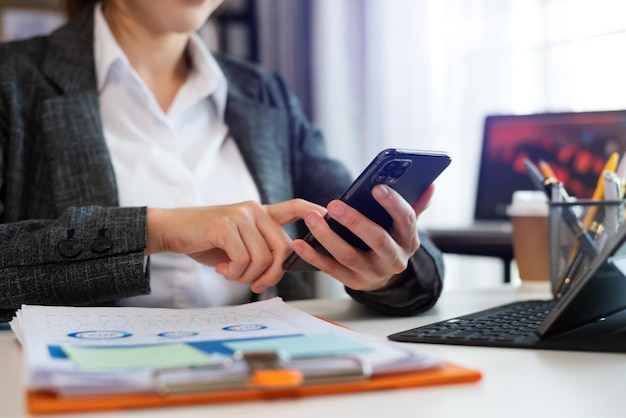 Businesswoman hand using laptop tablet and smartphone in office Digital marketing media mobile app and discussing plan new start up project