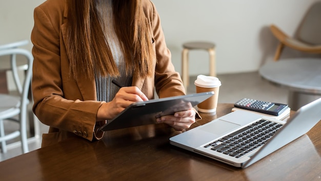 Businesswoman hand using laptop tablet and smartphone in office Digital marketing media mobile app and discussing plan new start up project