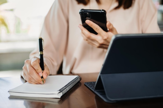 Businesswoman hand working with new modern computer and writing on the notepad strategy diagram