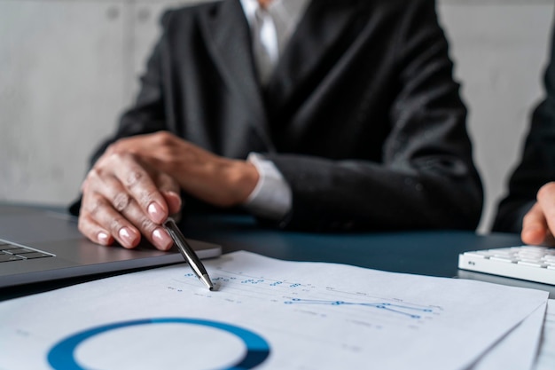 Businesswoman and her partner pointing at graph