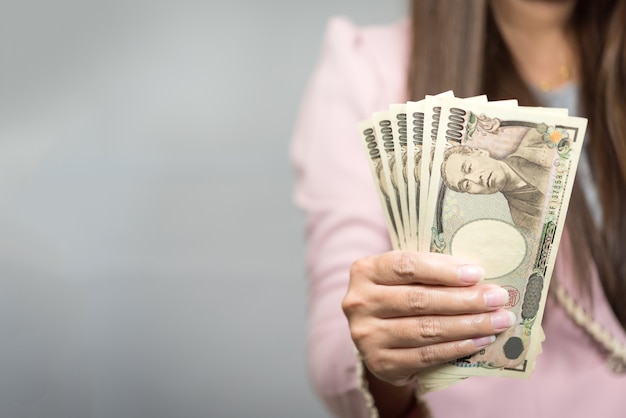 Businesswoman holding 10,000 Japanese Yen  money in hand 