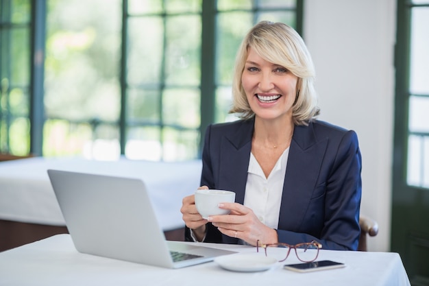 Businesswoman holding coffee cup in a restaurant