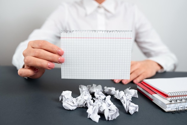 Businesswoman Holding Note With Important Message On Office Desk With Notebooks And Paper Wraps Woman Presenting Crutial Information Executive Showing Critical Data