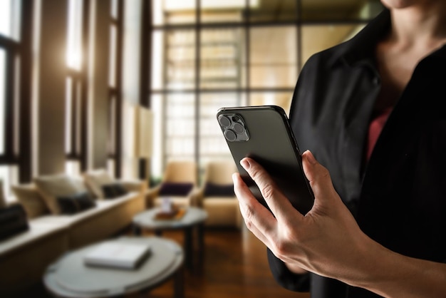 Businesswoman holding smartphone in her office room