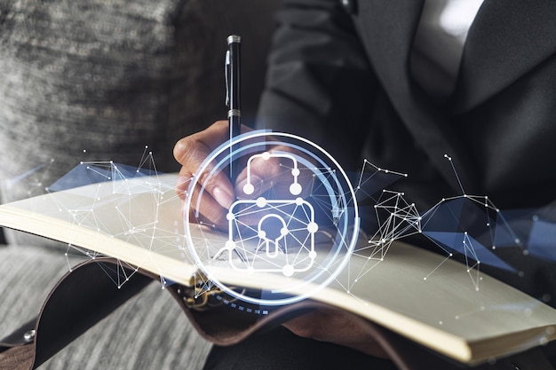 Businesswoman is taking notes of clients needs to protect cyber security from hacker attacks and save clients confidential data Padlock Hologram icons over the typing hands Formal wear