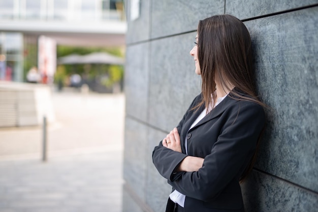 Businesswoman leaning against a wall