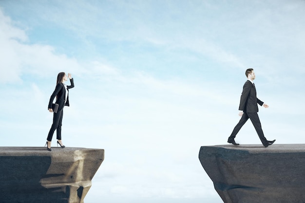 Businesswoman looking on businessman standing on mountain