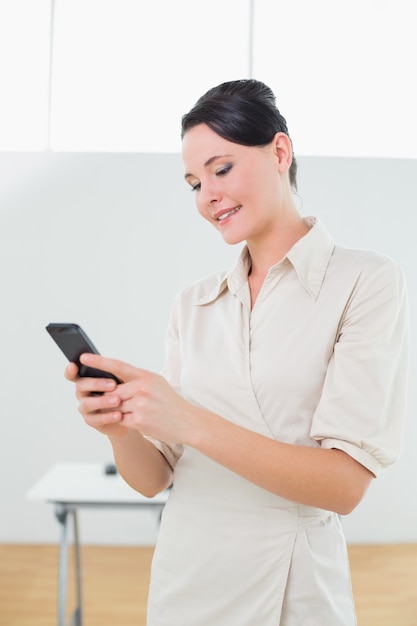 Businesswoman looking at cellphone in office