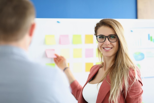 Businesswoman make notes on board lead presentation set goals for next year