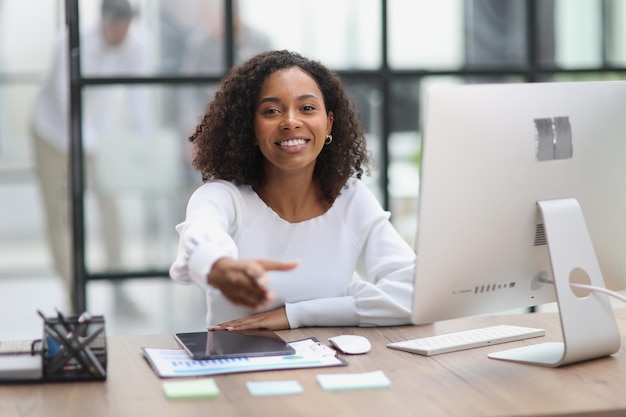 Businesswoman offering handshake standing with extended hand in