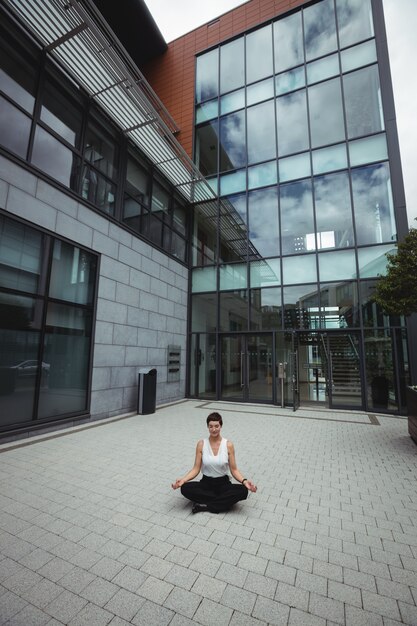 Businesswoman performing yoga