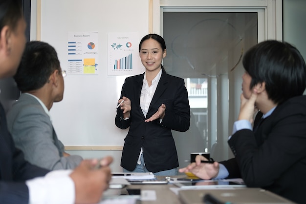 businesswoman present financial plan report to co worker team. woman leader discuss data