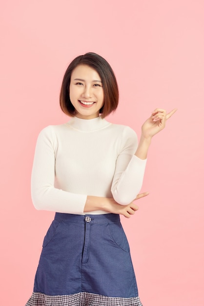 Businesswoman pressing button or something. Isolated on pink background