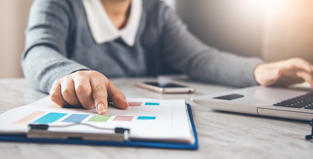 Businesswoman reviewing data in financial charts and graphs