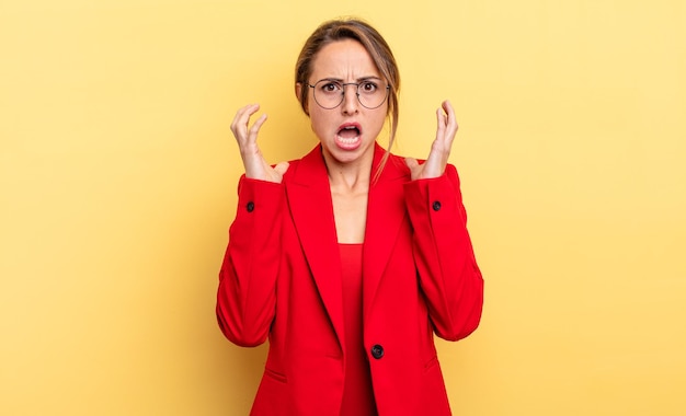 Businesswoman screaming with hands up in the air