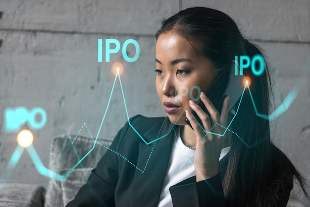 Businesswoman speaks phone and ipo icon hologram Double exposure Initial primary offering invest concept