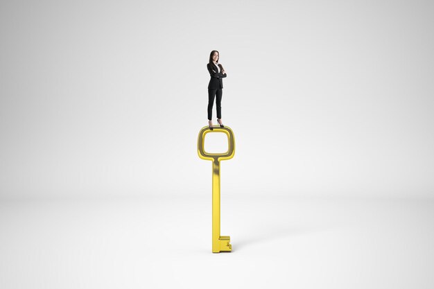 Photo businesswoman standing on golden key and looking into the distance on white background access and vision concept