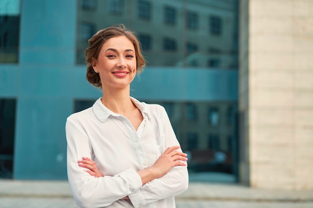 Businesswoman successful woman business person standing arms crossed outdoor corporate building exterior Smile happy caucasian confidence professional business woman middle age female entrepreneur