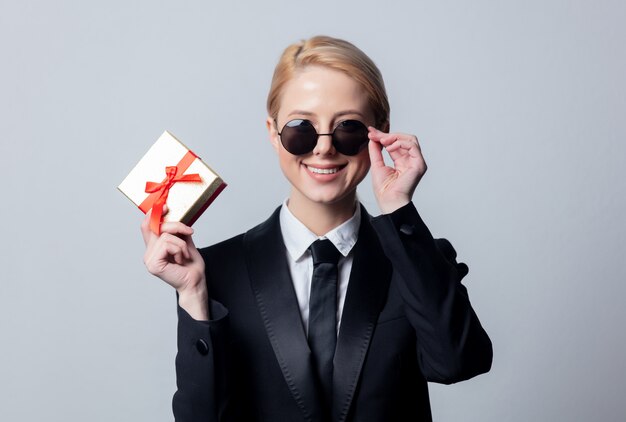 Businesswoman in sunglasses with gift box