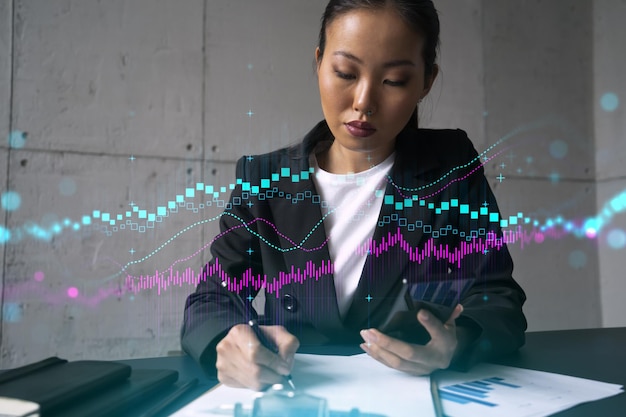 Businesswoman taking notes and forex graph hologram Double exposure Business technology online trading stock market solution concept