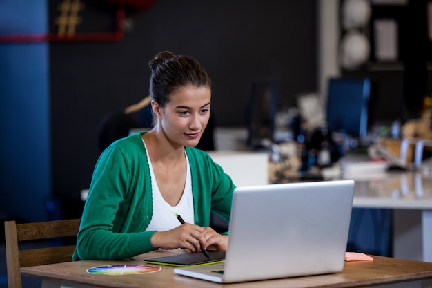 Businesswoman taking notes on her tablet computer