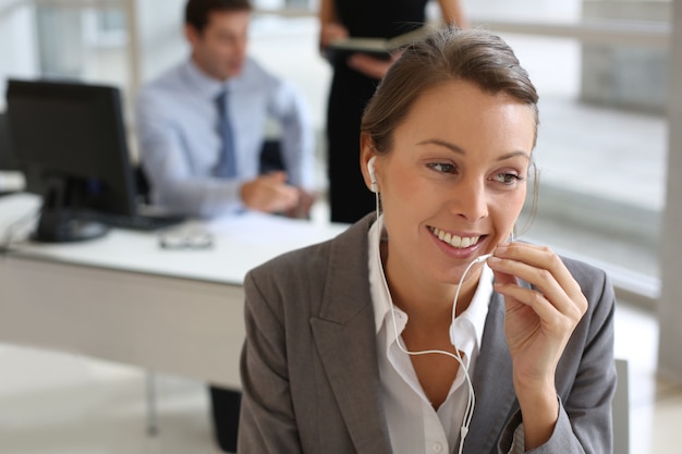 Businesswoman talking on mobile phone with handsfree device