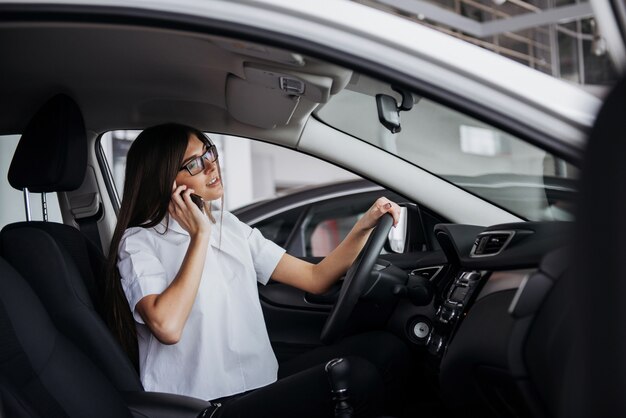 Businesswoman talking on the phone in car.