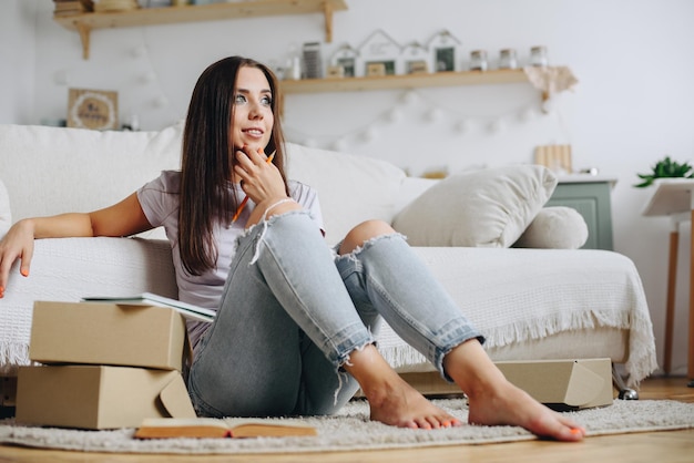 Businesswoman thinking while sitting on the floor in front of sofa and looking to side out window