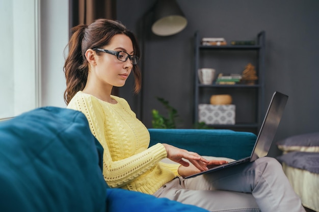 Businesswoman typing an email on laptop at home office